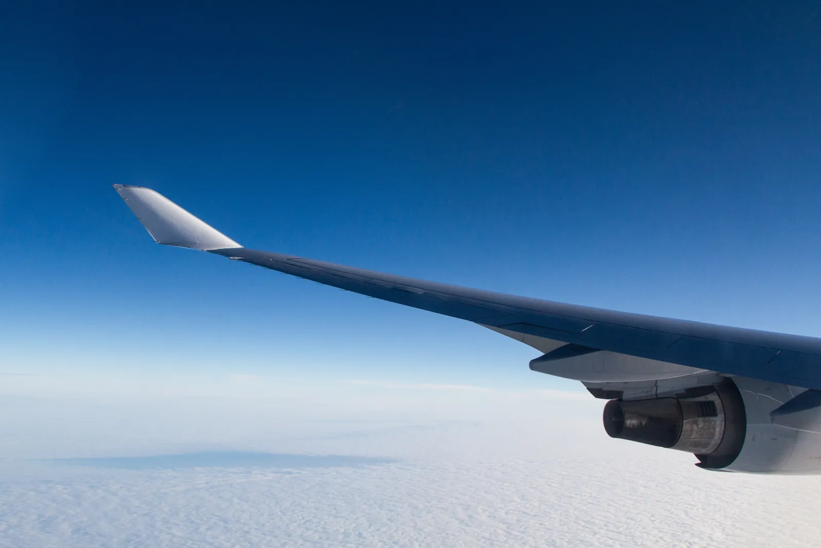 Aile d'avion au-dessus des nuages vue depuis le hublot