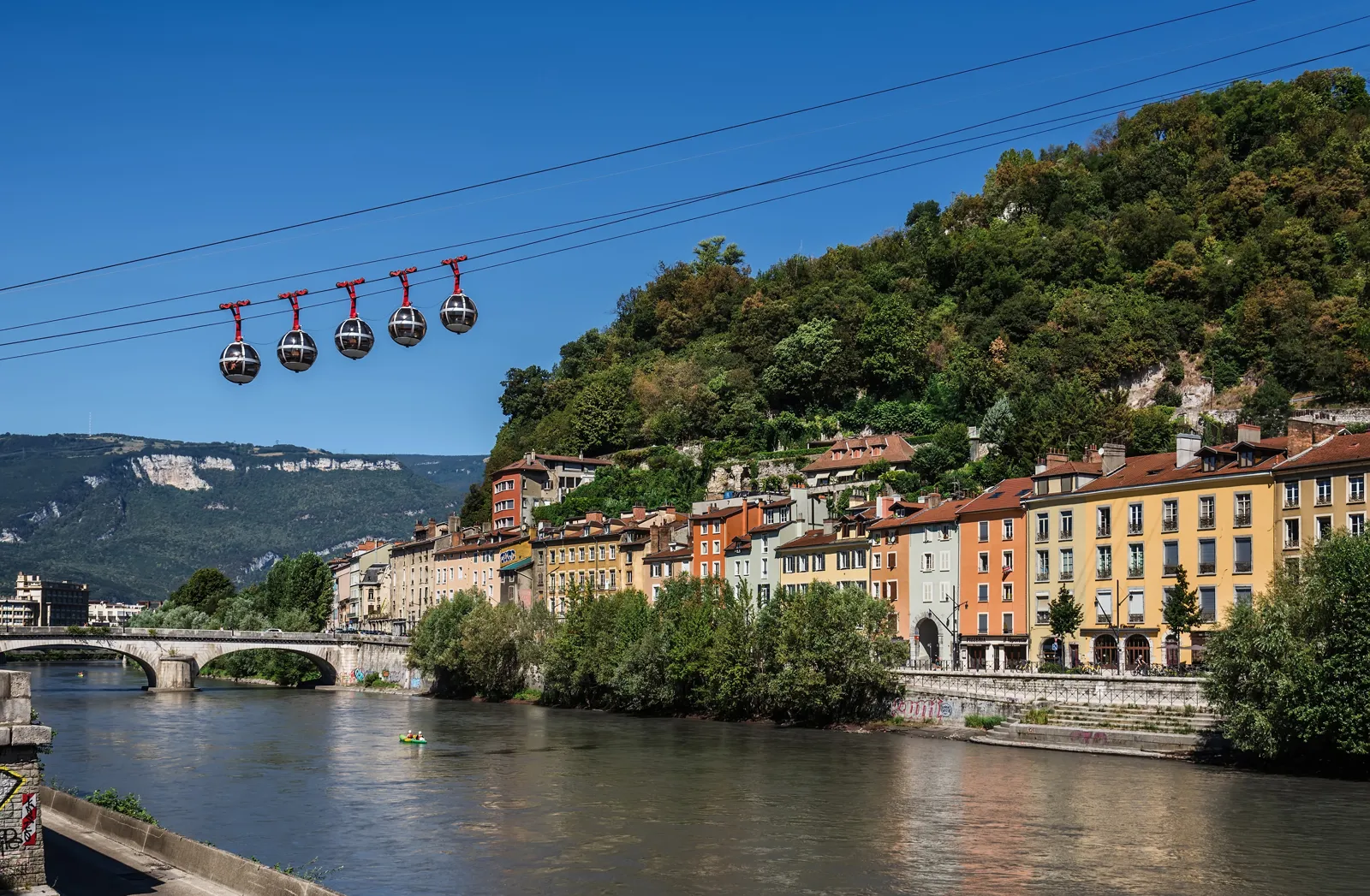 Que faire à Grenoble ? Bastille, vieille ville et massifs Les « bulles » du téléphérique de la Bastille au-dessus de l'Isère et des quais de Grenoble