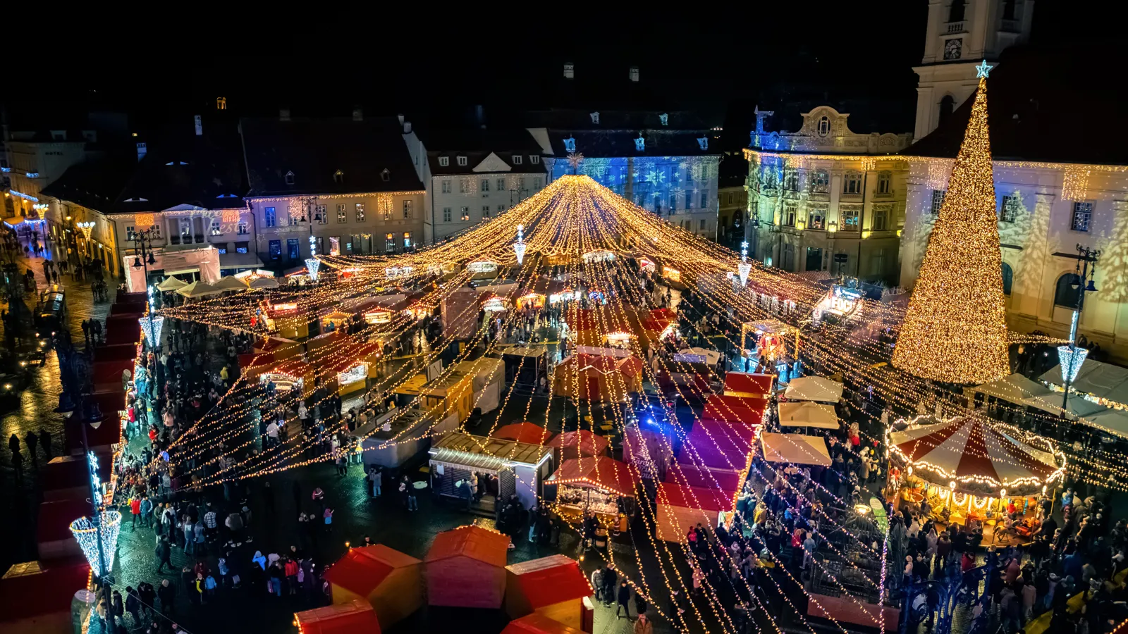 Marchés de Noël en Europe : les plus beaux et comment les choisir Vue aérienne d'un marché de Noël illuminé sur la grande place de Sibiu
