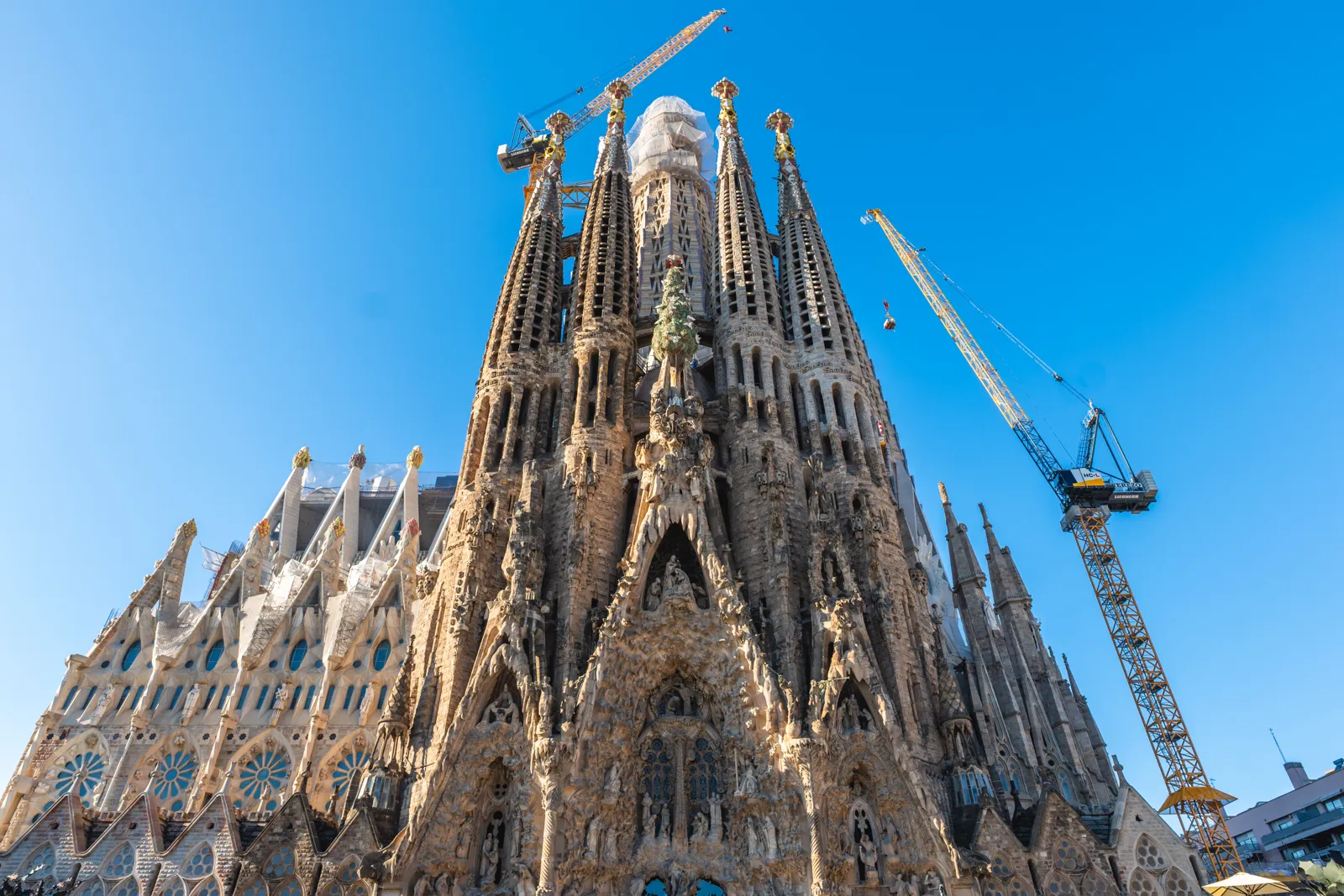 Façade de la Nativité de la Sagrada Família et ses tours, avec des grues de chantier