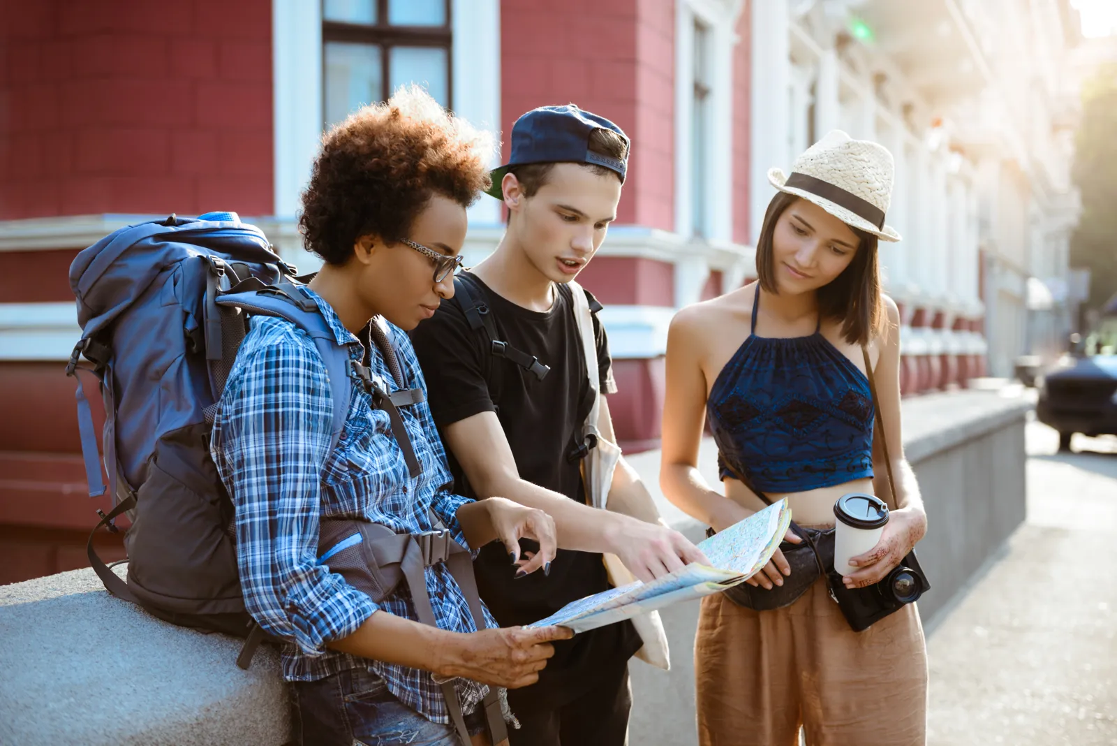 Voyager pas cher quand on est étudiant Jeunes voyageurs sac au dos consultant une carte dans la rue