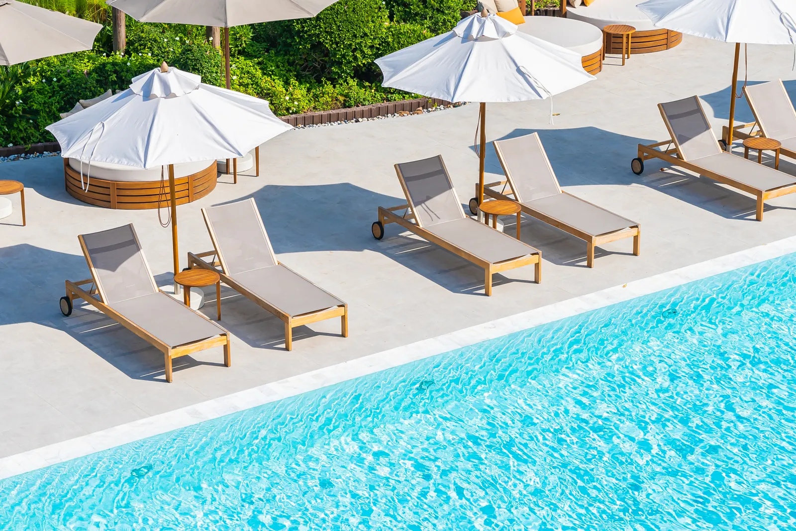 Voyage tout compris pas cher : comment bien choisir Piscine d'un hôtel club en bord de mer avec transats et parasols