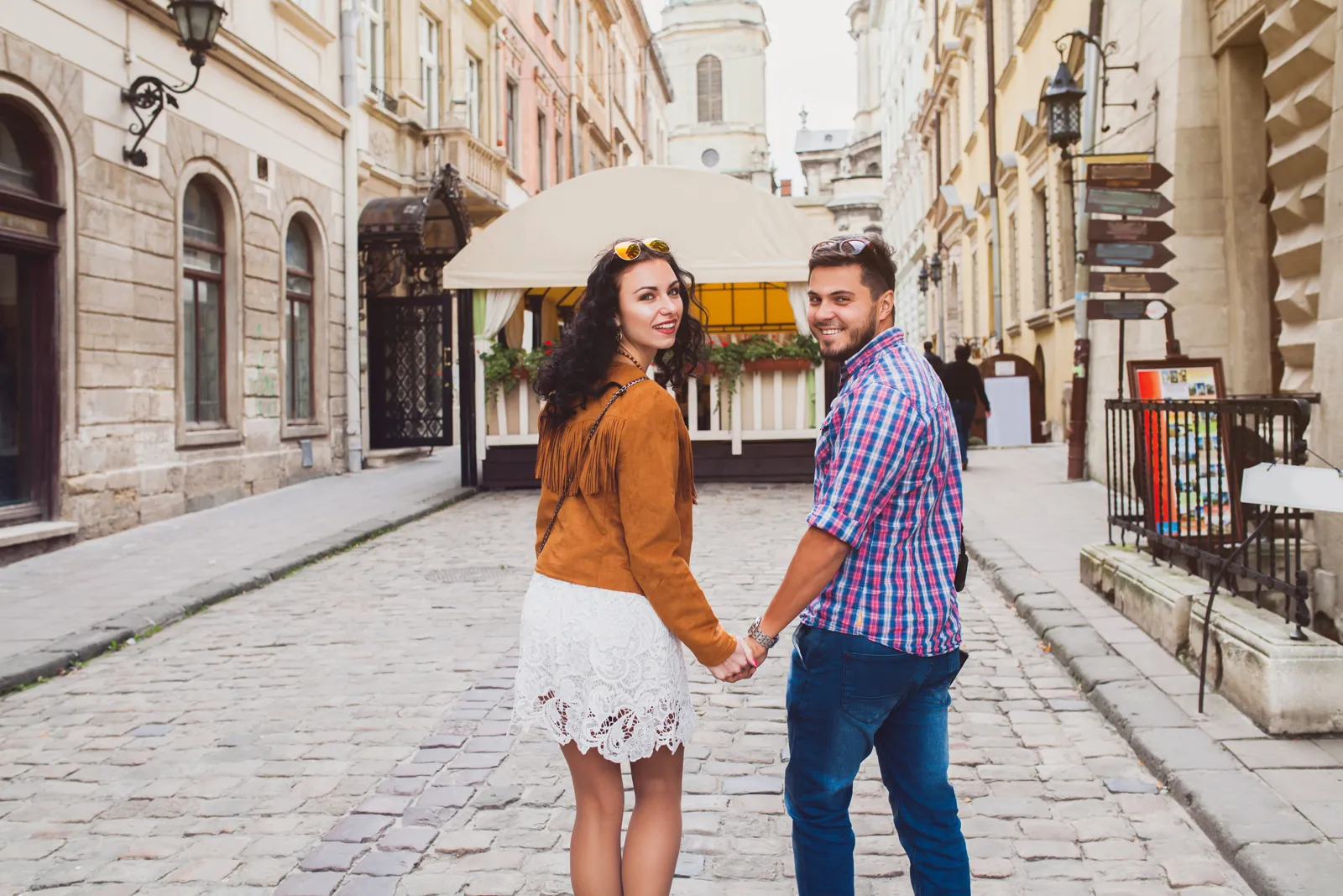 Week-end pas cher : comment l'organiser Couple se promenant dans une vieille ville européenne le temps d'un week-end